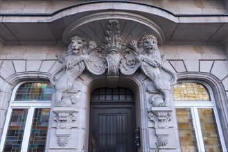 Lion sculptures with coat of arms above the entrance of a residential and commercial building
