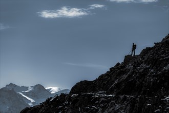 Mountaineers on mountain ridge in the background glaciated mountains