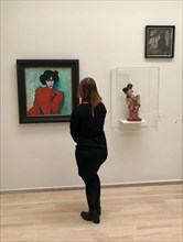 Young woman looking at painting Portrait of the dancer Alexander Sacharoff