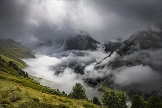 Mountain landscape in fog with dramatic clouds