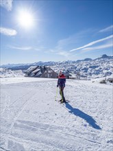 Blue sky above snowshoe hiker in winter landscape