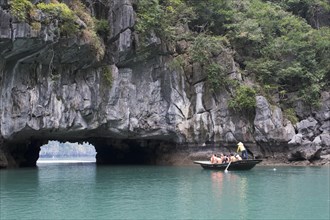 Rowing boat at the rock tunnel in Halong Bay