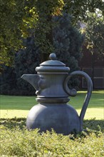 Metal sculpture coffee pot with face
