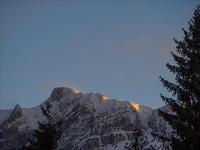 Evening light falling on snow-covered summit ridge