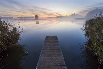 Wooden Jetty with Reflective Sky in Lake at Dawn