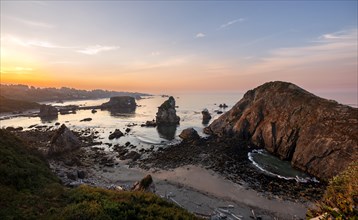 View of sea and sandy beach Harris Beach with rocks at sunrise