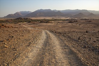 Gravel road towards the dry river bed of the Ugab river