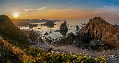 View of sea and sandy beach Harris Beach with rocks at sunrise