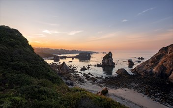 View of sea and sandy beach Harris Beach with rocks at sunrise