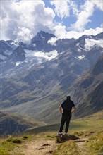 Hiker looking into the mountain massif of the Oetztal Alps in the rear Passeier Valley