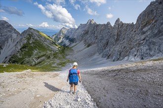 Hiker descends over a boulder field to the Lamsenjochhuette