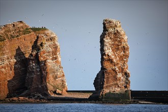 View from the sea to the rocky island of Helgoland with surf pillars Lange Anna and Kleine Anna