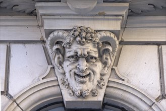 Head of a mixed creature above an entrance portal of a residential house