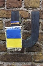 Flag in the national colours of Ukraine hanging from the letter U of Russia