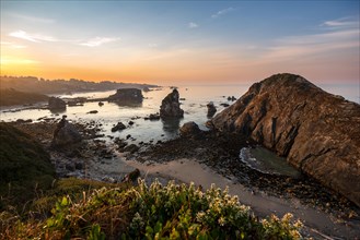 View of sea and sandy beach Harris Beach with rocks at sunrise