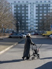 Senior citizen with a walker crossing a street