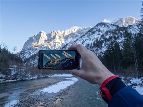 Tourist checks mountain peak with smartphone app Peak Lens