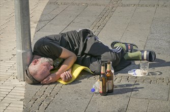Sleeping homeless man with beer bottles