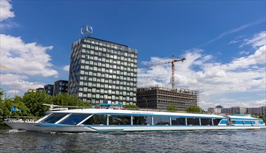 Passenger boats on the Spree at the Mercedes Benz Sales Headquarters and the Mercedes Benz Arena