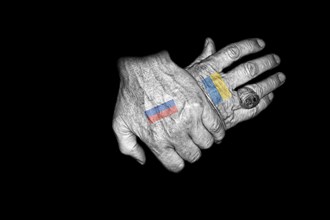 Two crossed hands with the Russian and the Ukrainian flag as tattoo on the back of the hand