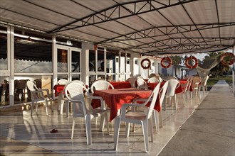 Terrace in front of restaurant with plastic chairs