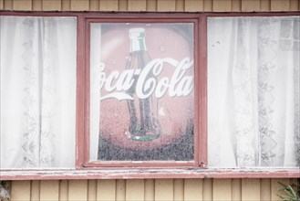 Old advertising sign for Coca-Cola in window