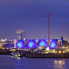 Blue illuminiete Koehlbrandhoeft sewage treatment plant in Hamburg harbour in the evening