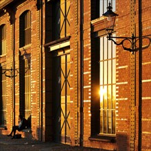 Shore-side facade of the Fischauktionshalle Hamburg-Altona at sunset