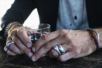 Men's hands with silver jewellery at a bar