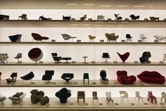 Many different miniature chairs in a showcase