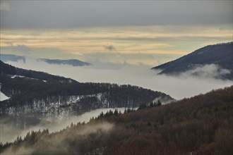 Fog lying in a valley at sunset