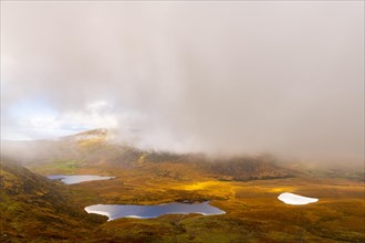 Autumn mountain landscape with small lakes and cloudy sky