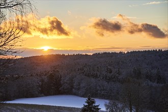 Sunset over a field and forest covered with snow near Wiesent