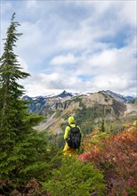 Hiker in front of Mt. Baker in clouds with snow and glacier