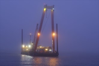 Illuminated dredger on the North Sea