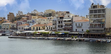 Residential houses and small fishing boats on the harbour promenade of Agios Nikolaos