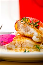 Sea bream orata fillet butter pan fried with fresh peach prune and dragonfruit slices thyme on top