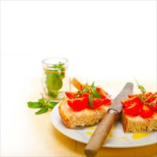 Italian tomato bruschetta with thyme and mint leaves