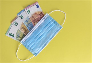 Medical masks and Euro currency banknotes. Financial crisis due to Coronavirus losses