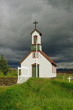 Wooden church and peat houses against dark clouds