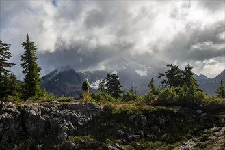 Hiker in front of cloudy Mt. Shuksan with snow and glacier