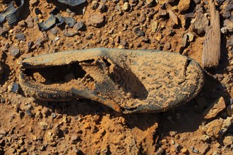 Fragment of rubber boot on red earth