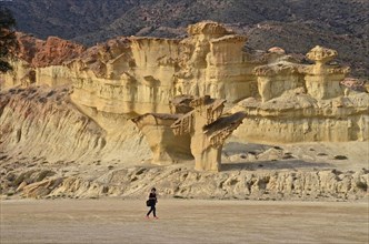 Woman walking in front of sandstone rock formations in Bolnueva