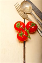 Ripe cherry tomatoes cluster over white rustic wood table