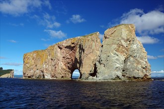 Large rock with gate stands in the sea