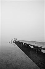 Empty bathing jetty in the morning mist
