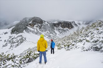 Two hikers on a hiking trail in the snow