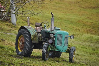 An old tractor standing on a meadow