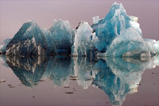 Blue iceberg reflected in smooth water