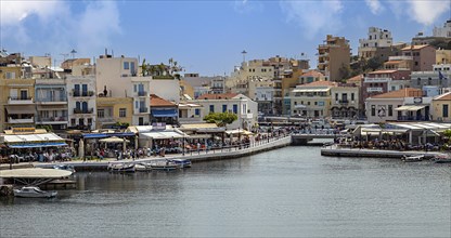 Residential houses and small fishing boats on the harbour promenade of Agios Nikolaos